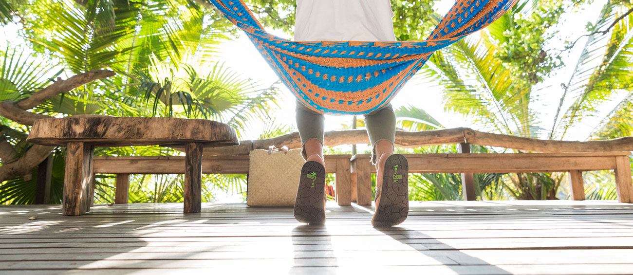 man sitting in a hammock in a tropical place
