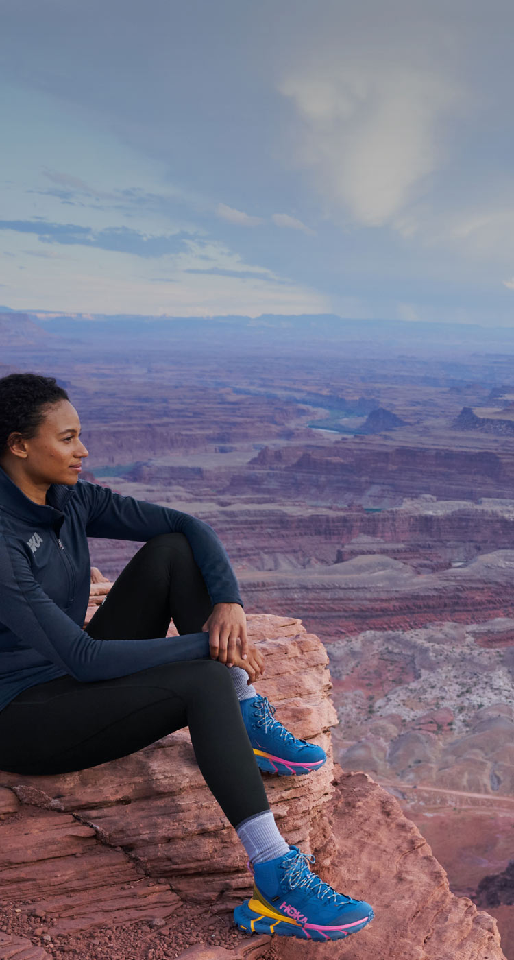 woman sitting above the grand canyon