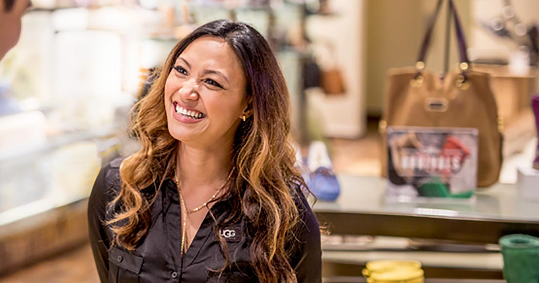 Smiling woman standing in an UGG retail store.