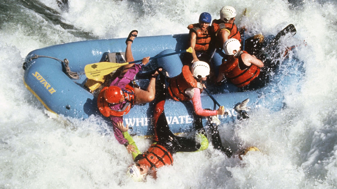 People whitewater rafting in big rapids
