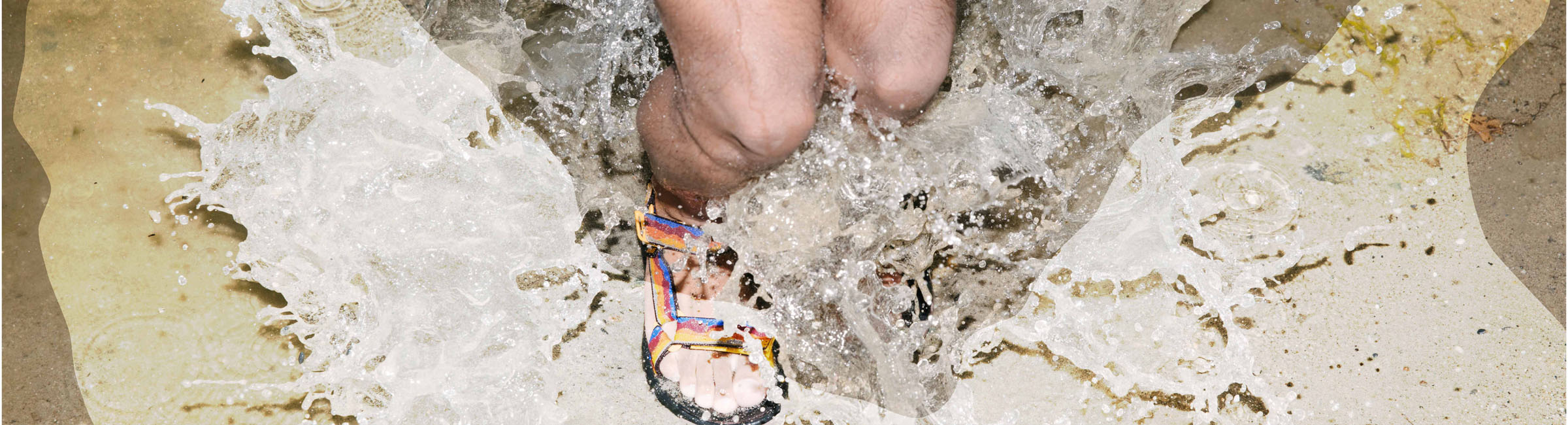person knees down in sandals splashing in puddle