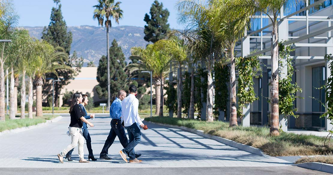 Four people crossing the street outside of Deckers Brands global headquarters.